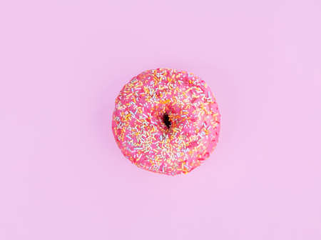 Pink donut with small candies on a pink backgroundの写真素材