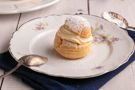 Vanilla cream puffs, for a snack, on a wooden table