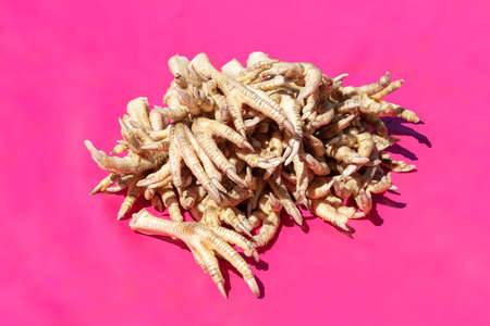 Pile of chicken feet in a Chinese market on a pink backgroundの写真素材