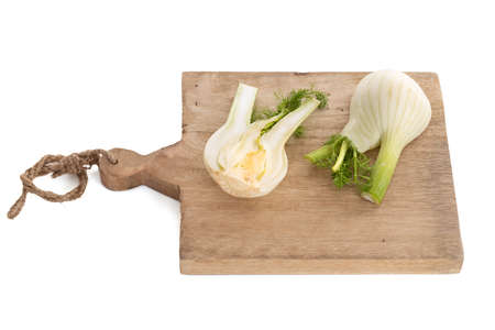 Fennel bulb isolated on a wooden cutting board on a white backgroundの写真素材