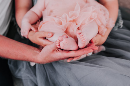 Parents hold baby by legsの写真素材