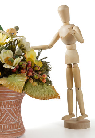 Wooden Mannequin With an Earthenware Jar Full of Flowersの写真素材