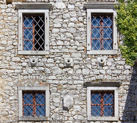Facade of a medieval castle with drystone wall and windowsのeditorial素材
