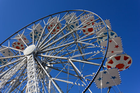 Ferris wheel decorated in red and blue against a blue sky