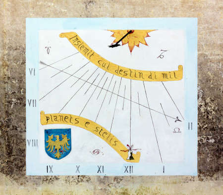 AQUILEIA, Italy - May 10, 2017: Sundial on an old building's exterior wall, with zodiac signs, an inscription written in Friulian language and the Friuli coat of arms.のeditorial素材