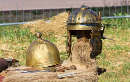 Ancient Roman helmets and daggers at a historical reenactmentの写真素材