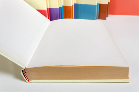 Book opened on a blank page surrounded by other similar books