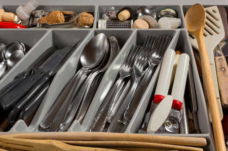 Close-up on on the contents of a kitchen drawer full of cutlery and utensilsの写真素材