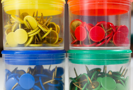 Four transparent colored thumbtack boxes