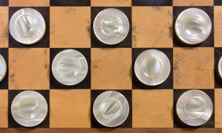 A few wooden pearly white pieces on a checkerboard
