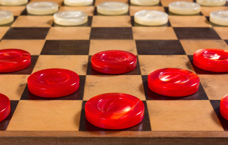 Red and white pearly pieces in the starting position on a checkerboard