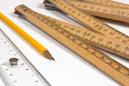 A measuring stick, a ruler and a pencil on a white backgroundの写真素材