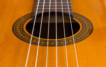 Close-up of a classical guitar's body with the sound hole in the center