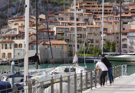 DUINO AURISINA, Italy - April 14, 2018: Two boys leant against a railing at the marina in Portopicclo, near Trieste, Italyのeditorial素材