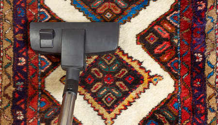 Close-up of a vacuum cleaner on an oriental carpetの写真素材