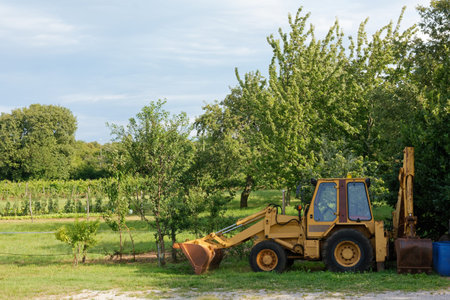 Yellow tractor parked at the margins of a cultivated area