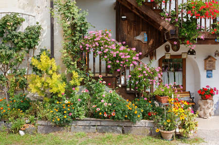 FELTRE, Italy - August 13, 2020: Close-up of the facade of a traditional country house decorated with plants and flowersのeditorial素材