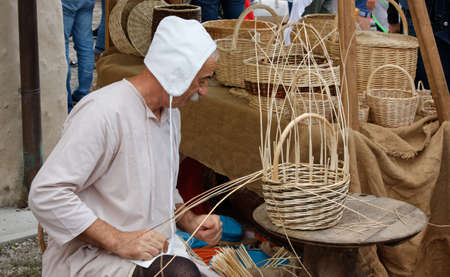 VALVASONE, Italy - September 14, 2014: Basket maker at work at the local medieval historical reenactmentのeditorial素材