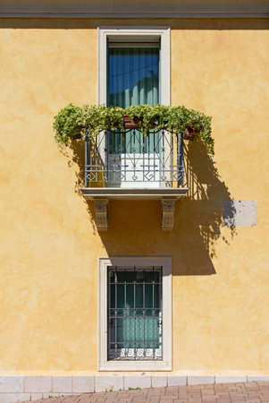 Detail of the exterior of an elegant urban building, with a wrought-iron decorated balconyの写真素材