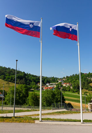 Two waving National flags of Slovenia against a countryside landscapeの写真素材