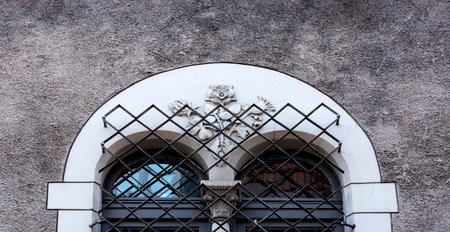 Window of an old house with a wrought iron lattice on the facade