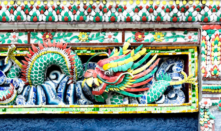 Colorful dragon sculpture on the wall of Buddhist temple in Thailand.の写真素材
