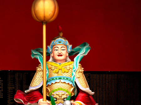 Goddess Guan Yin statue on red wall background, china