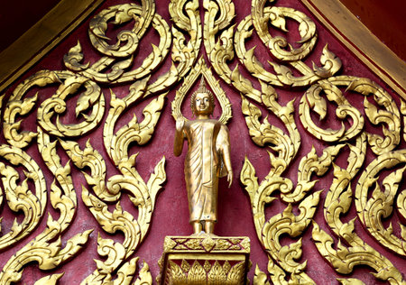 Golden buddha statue on the wall of Thai temple, Thailand.
