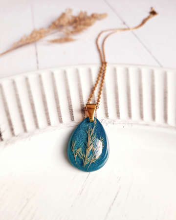 drop shaped golden necklace with dried flower, epoxy resin, women's jewelryの写真素材