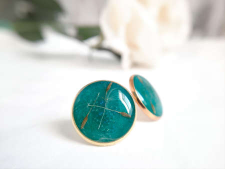 gold round earrings with dried dandelion, blue turquoise epoxy resinの写真素材