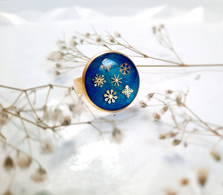 Gold handmade ring with a blue eye with sunken golden snowflakes, epoxy resinの写真素材