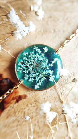 Gold bracelet with dried wild carrot flower, turquoise epoxy resin jewelryの写真素材