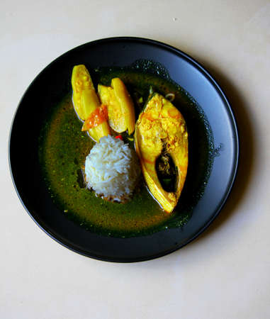 Hilsha fish curry with white rice and vegetablesの写真素材