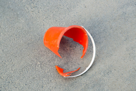 Broken Orange Bucket on Asphalt with white Handle.の写真素材