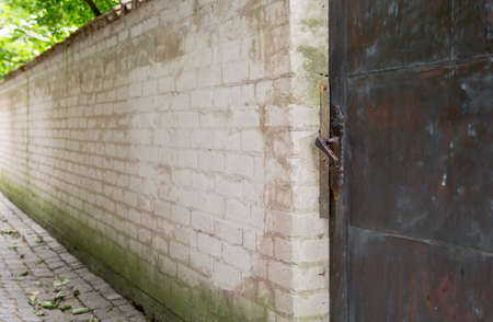 Metal Door in Brick Wall with cobblestone street.の写真素材