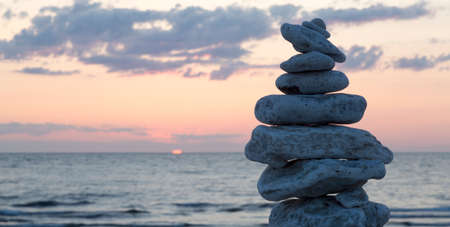 Rocks Piled on Each Other by ocean at sunset.の写真素材