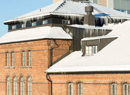 Icicles Hanging from Roof with snow in winter.の写真素材