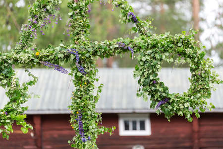 Swedish Traditional Midsummer Pole (Maypole) with a building in the background.の写真素材