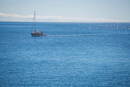 Sailboat on Ocean with a partly cloudy sky.