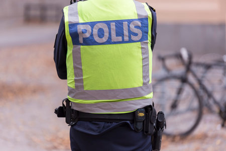 Swedish Police Officer back with gun.
