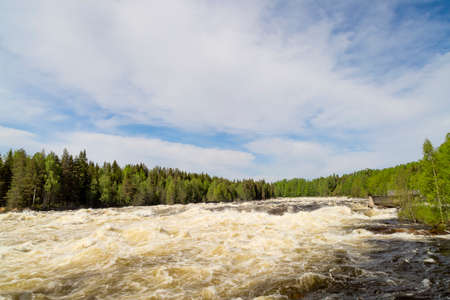 The rapids at Renforsen in Vindeln, Sweden with a partly cloudy sky.の写真素材
