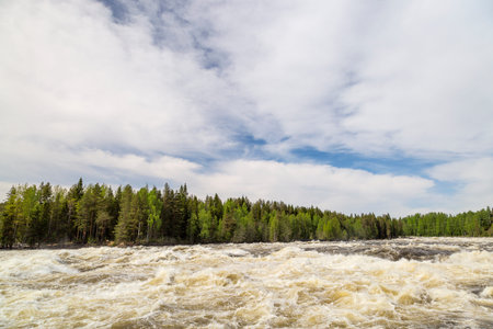 The rapids at Renforsen in Vindeln, Sweden with a partly cloudy sky.の写真素材