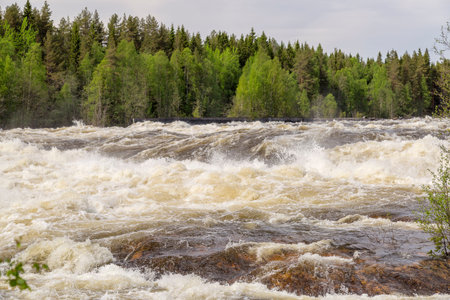 The rapids at Renforsen in Vindeln, Sweden with a partly cloudy sky.の写真素材