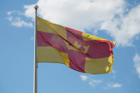 The Flag of the Swedish Church with a partly cloudy sky.の写真素材