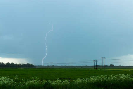 Lightning over Agricultural Field with a cloudy sky.の写真素材