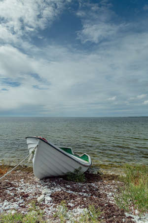 Boat on Shore by Ocean with a cloudy sky.の写真素材