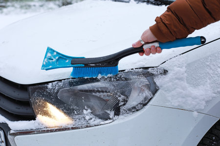 woman clears her car of snow, white car in the snow. High quality photoの写真素材