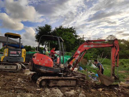 A little boy drives a small excavator to help his father work.の写真素材