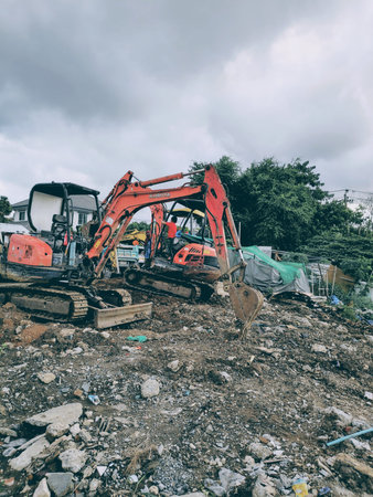 A little boy drives a small excavator to help his father work.
