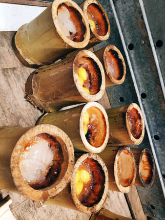 Khao Lam (Sticky rice in bamboo) is a sticky rice mixed with coconut milk and black beans with a little sugar and salt and then grilled over fire.の写真素材